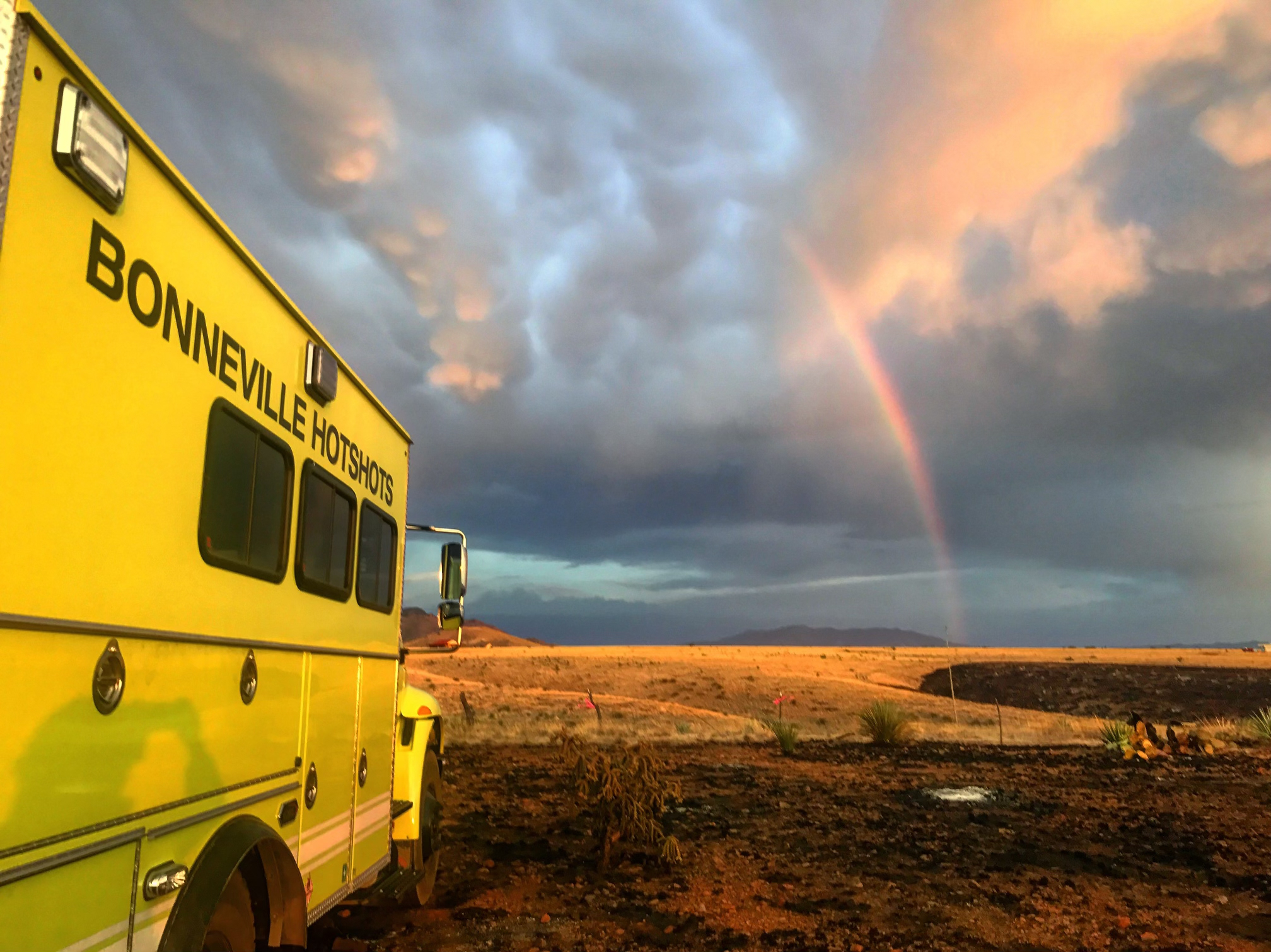Bonneville Hotshots vehicle with rainbow in the background.