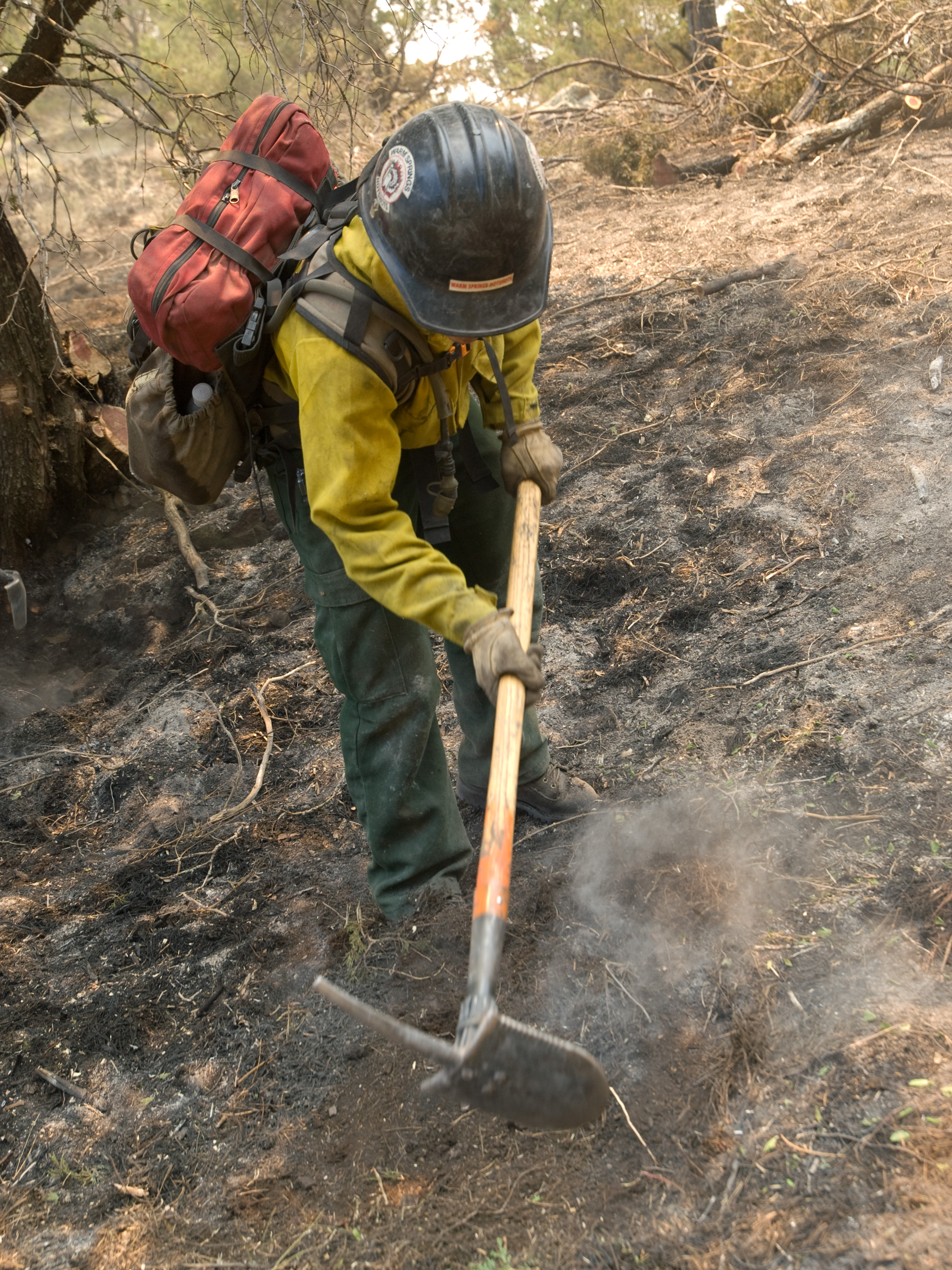 A wildland firefighter works on the Little Bear Fire