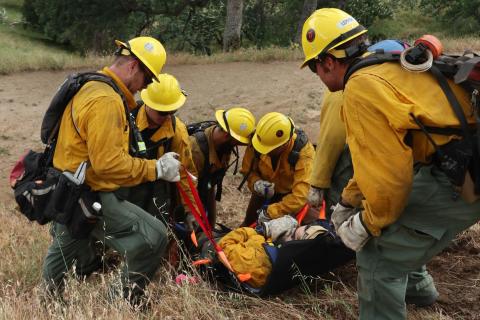 Firefighters attending to an injured firefighter